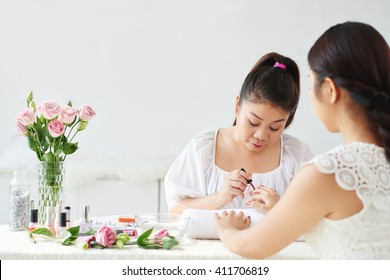 Young Asian Manicurist Working With Client In Beauty Salon