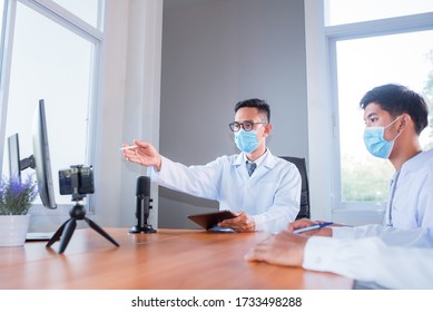 A Young Asian Medical Student Studied Medicine Through An Online Video Conferencing System Taught By An Asian Adult Doctor. Conferencing Concepts Or Online Video Conferencing Systems By Doctors