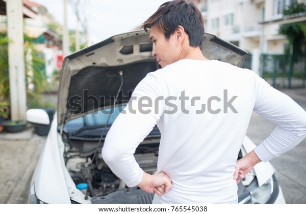 Young asian men\
worry about car failure on\
road