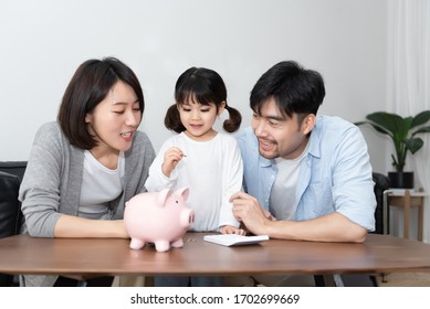 Young Asian Mom And Dad Are Saving Money With Daughter