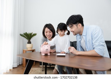 Young Asian Mom And Dad Are Saving Money With Daughter