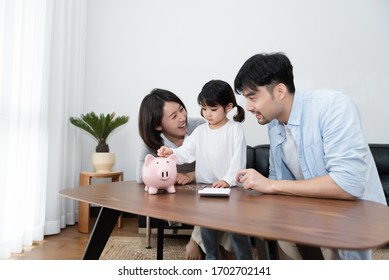 Young Asian Mom And Dad Are Saving Money With Daughter