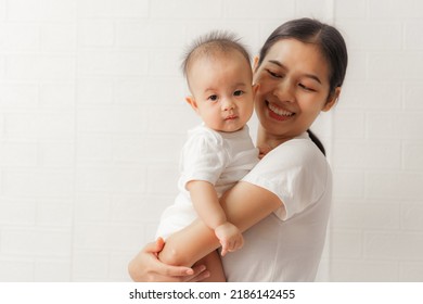 Young Asian Mom And Sweet Baby Daughter, Health Care Family Love Together. Asia Mother's Day Concept. Looking To Camera.