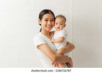 Young Asian Mom And Sweet Baby Daughter, Health Care Family Love Together. Asia Mother's Day Concept. Looking To Camera.