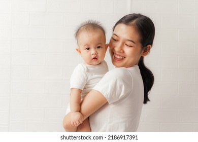 Young Asian Mom And Sweet Baby Daughter, Health Care Family Love Together. Asia Mother's Day Concept. Looking To Camera.