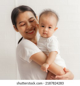 Young Asian Mom And Sweet Baby Daughter, Health Care Family Love Together. Asia Mother's Day Concept. Looking To Camera.