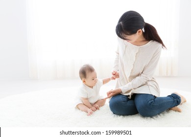 Young Asian Mother And Baby In The Room