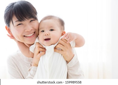 Young Asian Mother And Baby In The Room