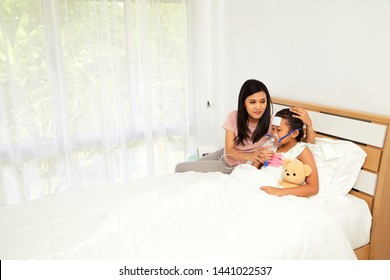 Young Asian Mother Child Sick Care At Home