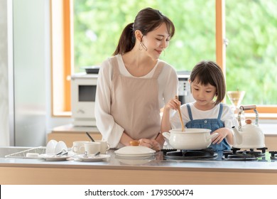 Young Asian Mother And Daughter Cooking At Kitchen