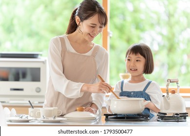 Young Asian Mother And Daughter Cooking At Kitchen