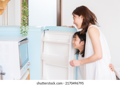 Young Asian Mother And Daughter Cooks In A Kitchen,Refrigerator