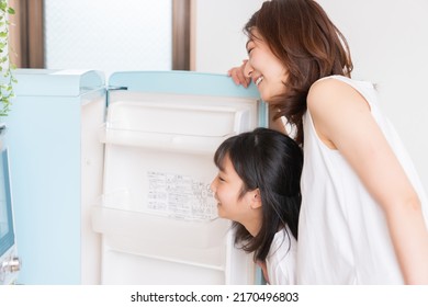 Young Asian Mother And Daughter Cooks In A Kitchen,Refrigerator