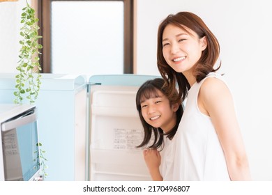 Young Asian Mother And Daughter Cooks In A Kitchen,Refrigerator