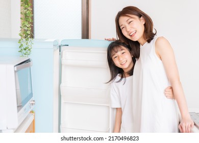 Young Asian Mother And Daughter Cooks In A Kitchen,Refrigerator