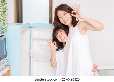 Young Asian Mother And Daughter Cooks In A Kitchen,Refrigerator