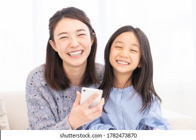 Young Asian Mother And Daughter,smart Phone