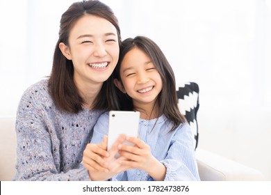 Young Asian Mother And Daughter,smart Phone