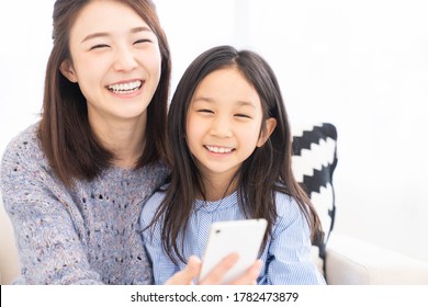 Young Asian Mother And Daughter,smart Phone