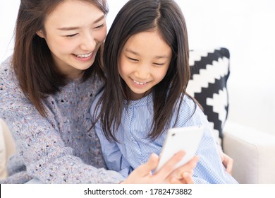 Young Asian Mother And Daughter,smart Phone