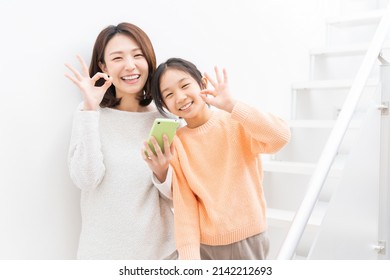 Young Asian Mother And Daughter,smart Phone