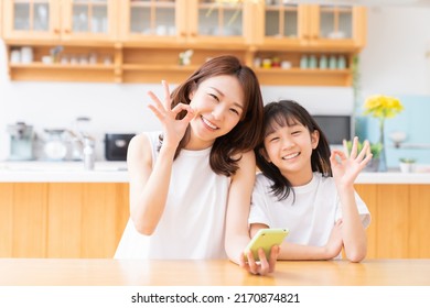 Young Asian Mother And Daughter,smart Phone