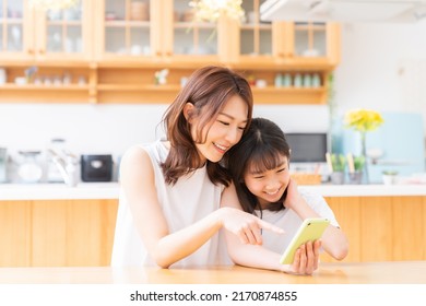 Young Asian Mother And Daughter,smart Phone