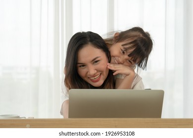 Young Asian Mother And Her Kid Using Computer To Video Call Online With Father At Home. Distance Communitacion Concept