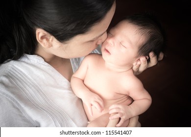 Young Asian Mother Lovingly Holds Her Newborn Baby Boy (5 Days Old)