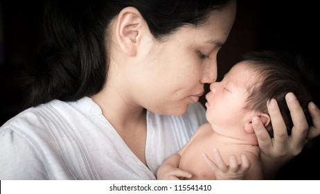 Young Asian Mother Lovingly Holds Her Newborn Baby Boy (5 Days Old)