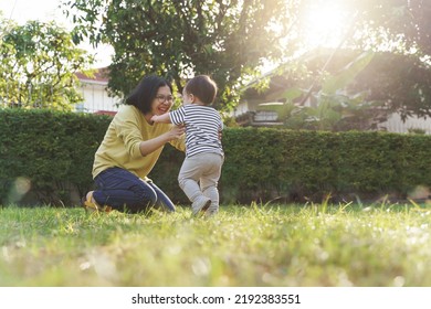 Young Asian Mother Playing With Son Outdoor, Little Boy Running Into Chinese Mom Embrace.