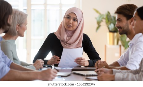 Young Asian Muslim Businesswoman Executive Wear Hijab Discussing Paperwork Financial Results Consult Clients Employees Group Explain Project Plan At Corporate Briefing Sit At Company Meeting Table