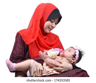 Young Asian Muslim Mother Enjoying Feeding Her Cute Baby Girl With A Milk Bottle Isolated On White Background