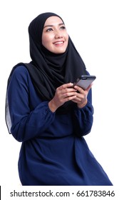 Young Asian Muslim woman in head scarf smile with smartphone and holding book.