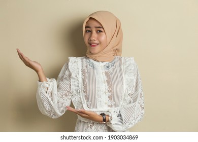 Young asian muslim woman wearing hijab smiling confident pointing with fingers to different directions. Copy space for advertisement
