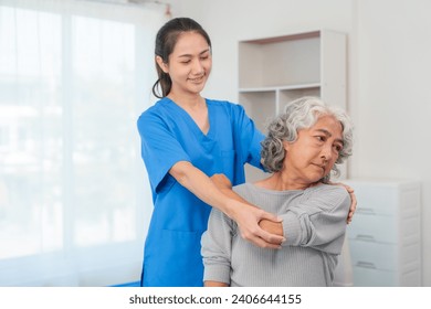 A young Asian nurse is assisting an elderly Asian woman with a grey hair during a physical therapy session. - Powered by Shutterstock