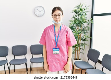 Young Asian Nurse Woman At Medical Waiting Room Relaxed With Serious Expression On Face. Simple And Natural Looking At The Camera. 