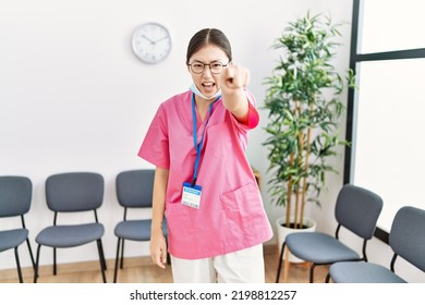 Young Asian Nurse Woman At Medical Waiting Room Pointing Displeased And Frustrated To The Camera, Angry And Furious With You 