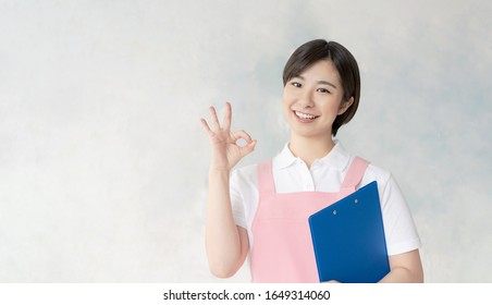 Young Asian Nursery School Teacher Showing OK Sign.