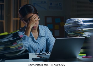 Young Asian office employee feeling tired, fatigue, exhausted while working overtime at night in office - Shutterstock ID 2178345725
