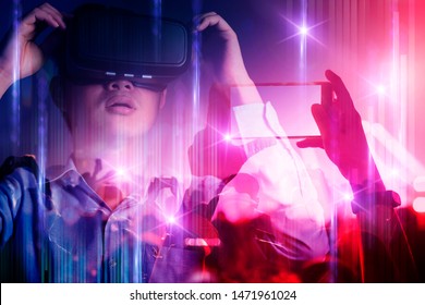 young asian officer man playing vr goggle and hand touch effect of magic of Virtual reality  in live concert music performance virtual reality atmosphere event - Powered by Shutterstock