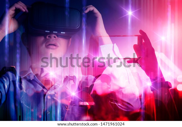 young asian officer man playing\
vr goggle and hand touch effect of magic of Virtual reality  in\
live concert music performance virtual reality atmosphere\
event