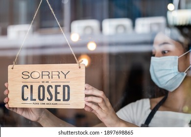 Young Asian Owner Retail,coffee Shop Woman Turning Sign Board To Closed With Wearing Face Mask,protection To Pandemic Of Coronavirus.Close Store,restaurant Or Pub Due To Lockdown, Quarantine Of Covid.