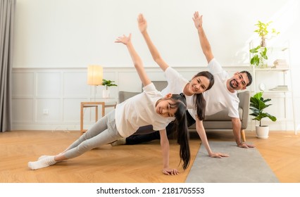 Young  Asian Parents With Child Meditating At Home Isolated In Room.  Family, Sport, Yoga Concept.