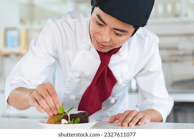 Young Asian pastry chef serving dessert - Powered by Shutterstock