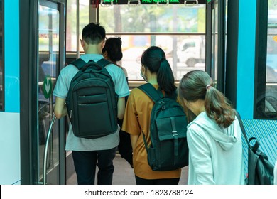 Young Asian People Getting On The Bus