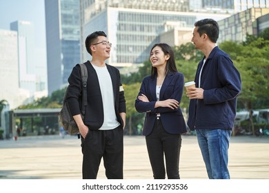 Young Asian People Standing Talking On Street Happy And Smiling