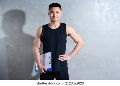 Young Asian Personal Trainer Posing On Gray Background