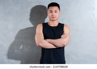 Young Asian Personal Trainer Posing On Gray Background