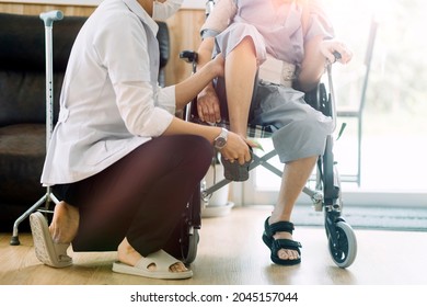 young asian physical therapist working with senior woman on walking with a walker